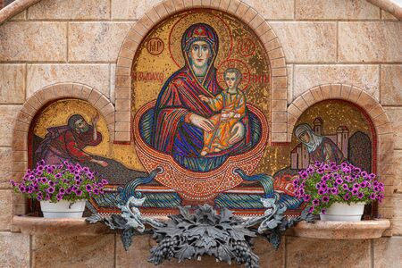 Minsk, Belarus. - May, 2019. Close-up of waterworks with flowers and mosaical image of Mary Virgin...