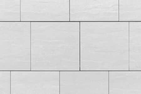 Large grey tile pattern surface on wall, background close-up.
