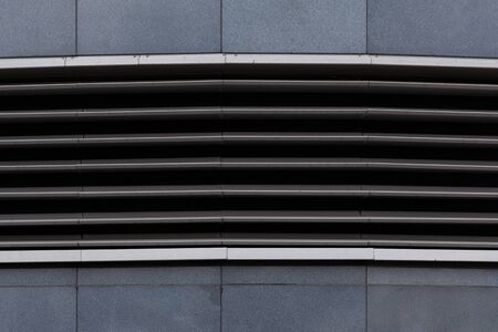 Horizontal ground ventilation grate on gray tiled floorの写真素材