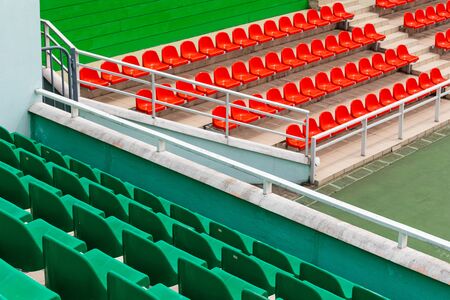 Diagonal view of competition venue with green and orange spectator seats.