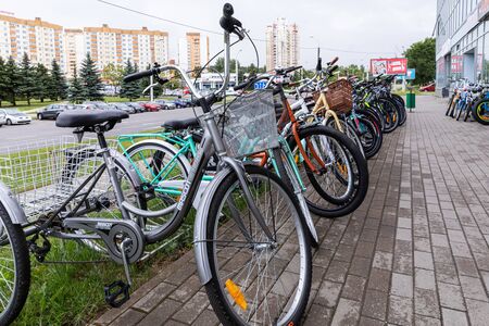 Minsk, Belarus - July 17, 2019: Bike-stand with many bicycles standing on wet pavement tiles.のeditorial素材