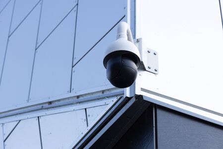 Close-up of high-tech video browsing camera on white building. Photo with depth of field