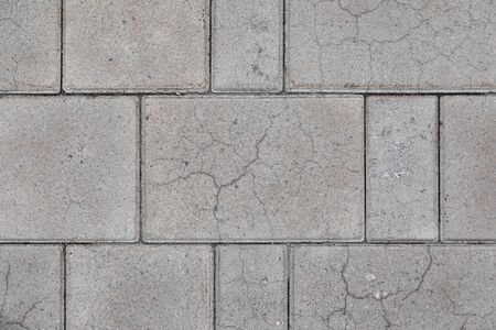 Closeup of little bit cracked gray street tile