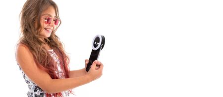 Panorama of smiling girl in square red sunglasses holding black cellphone LED lamp for selfie isolatedの写真素材