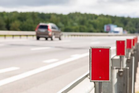 close-up of signposts with red reflective elements along highway. Photo with depth of field