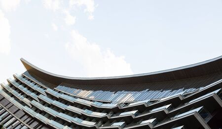 Ground view of modern glass building against clear blue sky