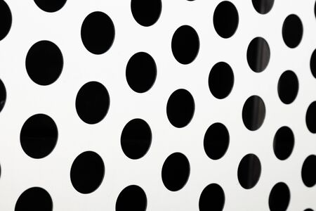 Black big dot pattern on white background, round holes texture on perforated metal panel surface, diagonal viewの写真素材