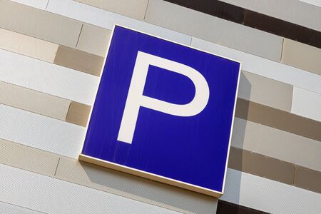 Close-up of european parking sign on metal striped wall of different light color shades