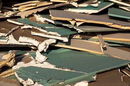 Unusable sheetrock laying in a pile on dumping site
