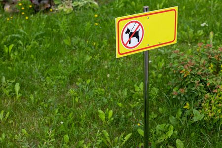 Yellow sign of animal walk prohibition on grass.の写真素材