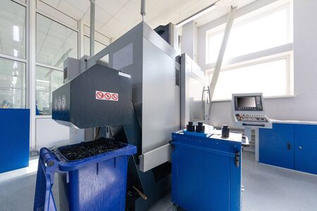 Equipment for cutting metal and containers filled with swarf. Photo with depth of field