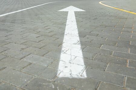 Angular view of traffic sign white arrow pointing direction for vehicles. Wide angle view