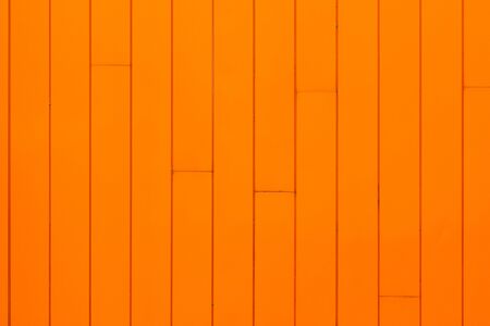 Bright orange building facade, painted wooden panels on wall.の写真素材