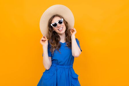 Stylish girl tourist on an orange   looking at the camera with a smileの写真素材