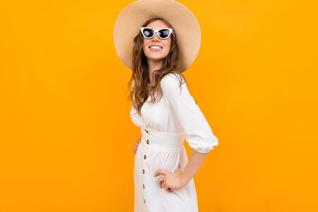 Stylish girl in a snow-white dress on an orangeの写真素材