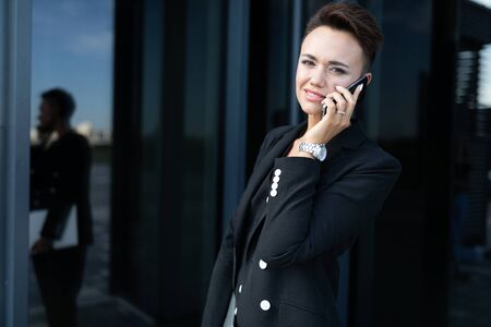 photo of a young ambitious businesswoman on the background of a modern office buildingの写真素材