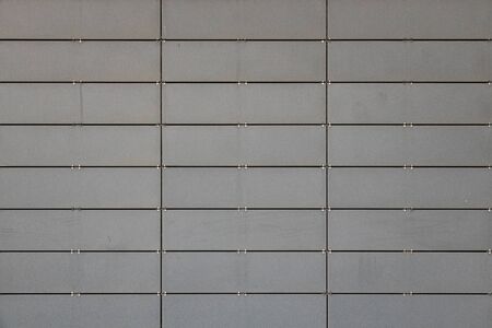 Front view of light grey wall made of small metal tilesの写真素材