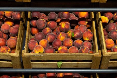 Wooden lug box with soft and mellow peaches on counter. Photo with depth of fieldの写真素材