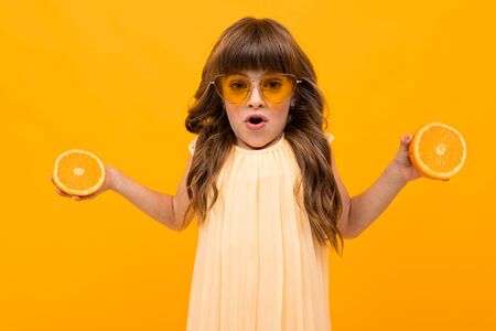 girl with oranges on a yellow background.