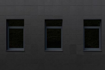 Black wall and big windows of tall building.