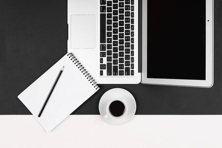 Desktop with laptop, note, pen isolated on black and white background.の写真素材
