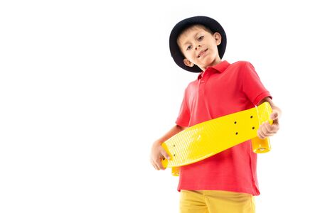 attractive young smiling boy holds a yellow skateboard on a white background with copy space.の写真素材