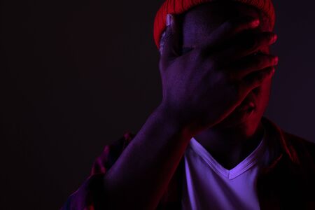 Closeup portrait of a stylish handsome african black man in neon light.の写真素材