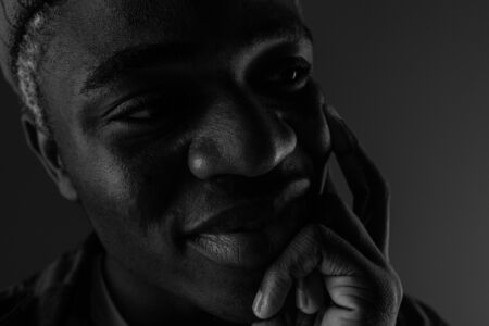 Closeup portrait of a black smiling American man with big lips in black and white light.の写真素材