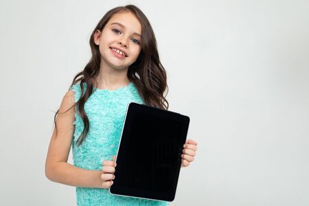 smiling girl holding a tablet with a template for inserting a web page or advertisement on a white background.の写真素材