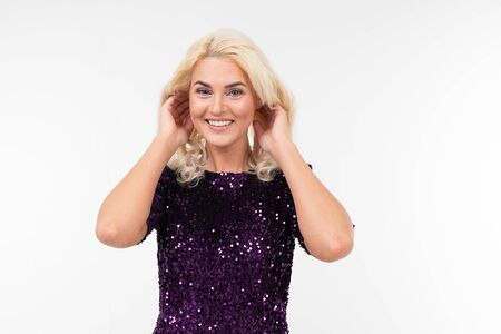 charming surprised blonde girl in purple beautiful elegant dress on a white background with copy...