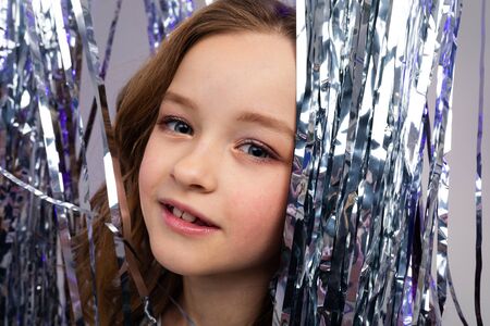 Closeup portrait of a stylish teenage girl on shiny sparkling background.