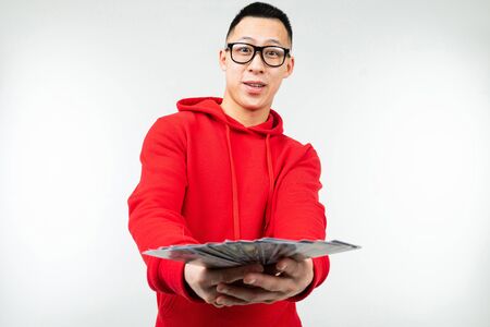 man holds dollars in his hands on a white studio background with copy space.
