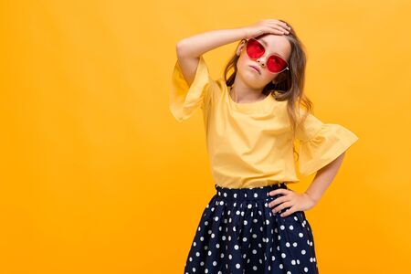 stylish young girl posing isolated on a yellow studio background.の写真素材