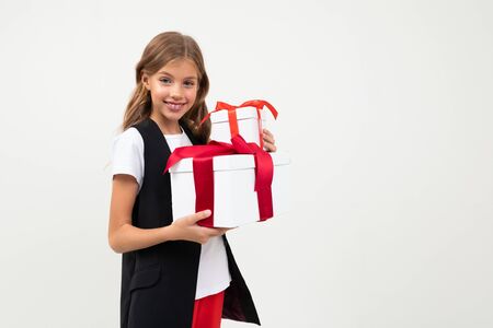 Picture of beautiful little girl with long wavy hair holds a white boxes with gifts and smiles