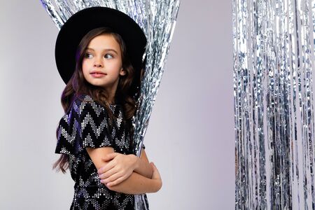 glamorous lady teen girl in a stylish outfit with a black hat in the studio at a party.の写真素材