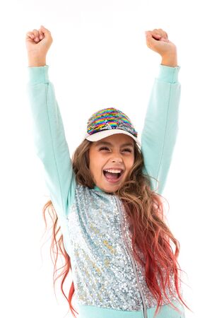 Little pretty caucasian girl in a tracksuit dancing and rejoicing, picture isolated on white background.の写真素材