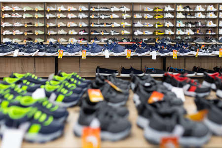 large shoe store with long shelves filled with shoes.の写真素材
