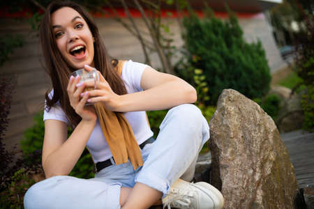 charming young business woman having coffee break sitting on cafe terrace.