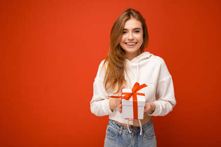 Beautiful happy young blonde woman isolated over colourful background wall wearing stylish casual...