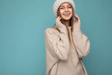 Beautiful positive happy young dark blonde woman isolated over colourful background wall wearing...
