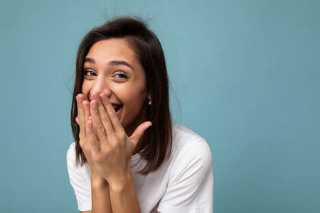 Portrait of happy positive young beautiful brunette female person with sincere emotions wearing...