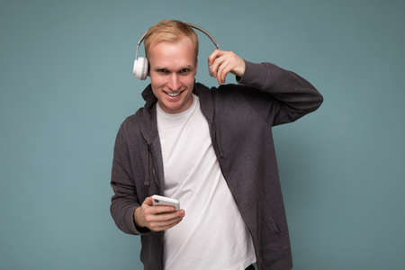 young man wearing casual white t-shirt isolated over blue background.の写真素材