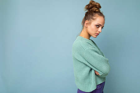 Photo of young attractive european fashion blonde woman wearing blue sweater isolated over blue background with copy space with serious expression on face. Simple and natural female person.の写真素材