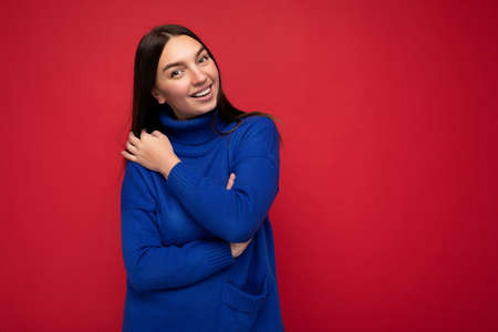Photo of beautiful positive smiling adult woman wearing stylish clothes standing isolated on...