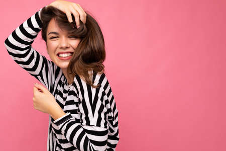Portrait of positive cheerful fashionable woman in casual clothes isolated on pink background with copy spaceの写真素材