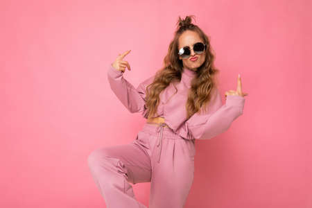 Photo of happy positive cool young beautiful blonde curly woman with sincere emotions wearing...