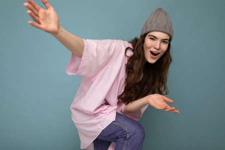 Beautiful positive happy young dark brunette woman isolated over colourful background wall wearing casual stylish clothes feeling sincere emotions looking at cameraの写真素材