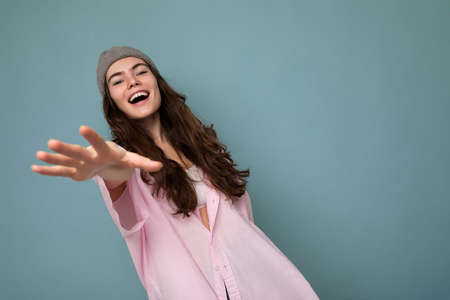 Beautiful positive happy young dark brunette woman isolated over colourful background wall wearing casual stylish clothes feeling sincere emotions looking at cameraの写真素材