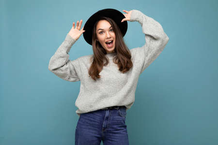 Portrait of young positive happy beautiful brunette lady with sincere emotions wearing stylish grey...