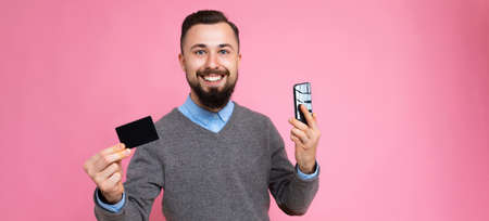 Panoramic photo shot of Handsome smiling brunette bearded young man wearing stylish grey sweater and...